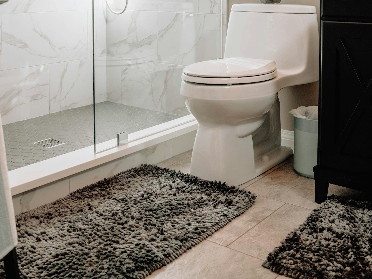 Clean bathroom with a glass shower and marble tile