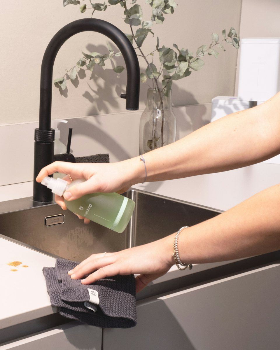 Checkout Clean cleaner spraying and wiping a kitchen sink in a Toronto condo